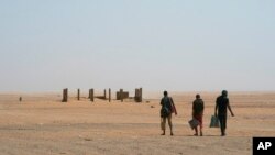 FILE: Three men head north towards Algeria after crossing the Assamaka border post in northern Niger. Taken 6.3.2018