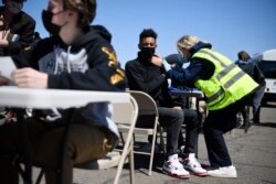 East Hartford High School junior Zander Robinson receives a vaccination from EMT Mary Kate Staunton of Clinton at a mass vaccination site at Pratt & Whitney Runway in East Hartford, Conn., Monday, April 26, 2021.