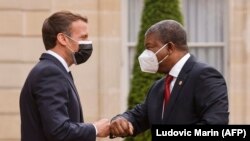 Presidente francês Emmanuel Macron (esq) cumprimenta o Presidente angolano João Lourenço, à chegada ao Palácio do Eliseu. Paris, 17 de Maio, 2021