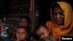 Sait Banu duduk di penampungan bersama anak-anaknya di kamp pengungsi Rohingya di Cox’s Bazar, Bangladesh, sambil menggenggam surat dari suaminya yang dipenjara di Myanmar, 28 Juni 2018.