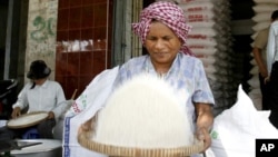 A Cambodian vendor cleans rice at her shop in a roadside market in Phnom Penh, Cambodia. (AP Photo/Heng Sinith)