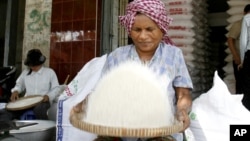 A Cambodian vendor cleans rice at her shop in a roadside market in Phnom Penh, file photo. 