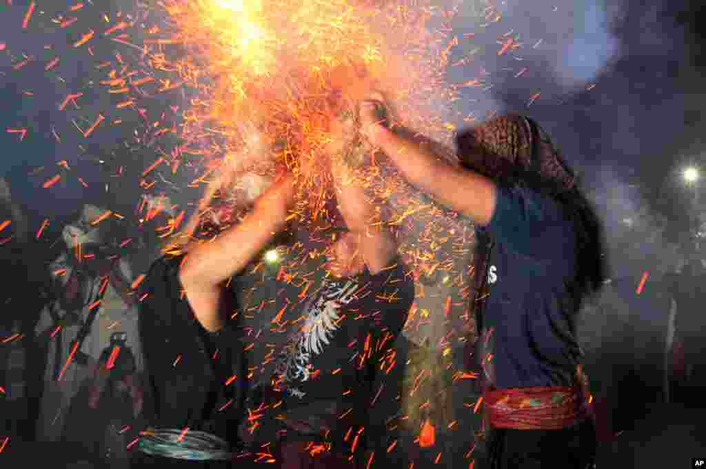 Men lash each other with burning coconut husks during the annual &quot;Mesiat Geni&quot; ritual at a Hindu temple in Bali, Indonesia, Sept. 28, 2015.