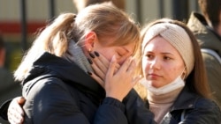 Students comfort each other as they gather outside the Perm State University following a campus shooting in Perm, about 1,100 kilometers (700 miles) east of Moscow, Russia, Sept. 21, 2021.