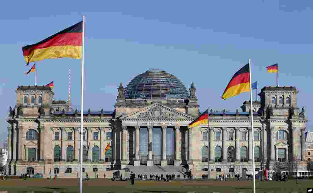 德国国会大厦，大厦前和大厦上飘扬着德国国旗。8月5日，在柏林市的国会大厦前,德国警察逮捕了行非法的纳粹礼的两名中国游客。警方称，他们互相用手机拍照行纳粹礼的样子。巡警以&quot;使用非法组织标志罪&quot;拘捕了这两名游客。他们每人交了500欧元保释金，获得保释。他们面临刑事调查。如果定罪，会被罚款或者判处最高三年刑期。德国刑法禁止传播或在公开场合使用违宪组织标志，而问候礼和旗帜、图形、制服、口号都属于&quot;标志&quot;。
