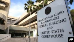 A sign for the Hawaii U.S. federal court stands outside the building in Honolulu on Wednesday morning, March 15, 2107. (AP Photo/Marco Garcia)