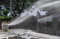 ရန်ကုန်မြို့ရှိ ဈေးတခုမှာ ပိုးသတ်ဆေးဖျန်းနေတဲ့ မီးသတ်ဝန်ထမ်းများနဲ့ စေတနာ့ဝန်ထမ်းတချို့ (ဧပြီ ၀၈၊ ၂၀၂၀)