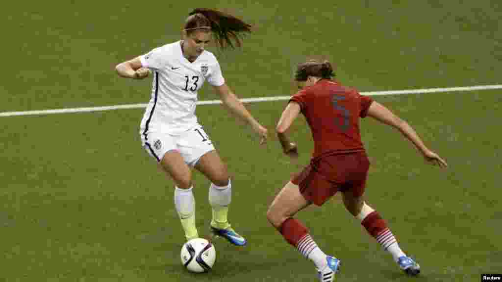 L'attaquante américaine Alex Morgan (13) contrôle la balle face à la défenseur à allemande Annike Krahn (5) au cours de la deuxième moitié de la demi-finale de la Coupe du Monde/Dames 2015 de la FIFA au Stade olympique, le 30 juin 2015 à Montréal, Québec.