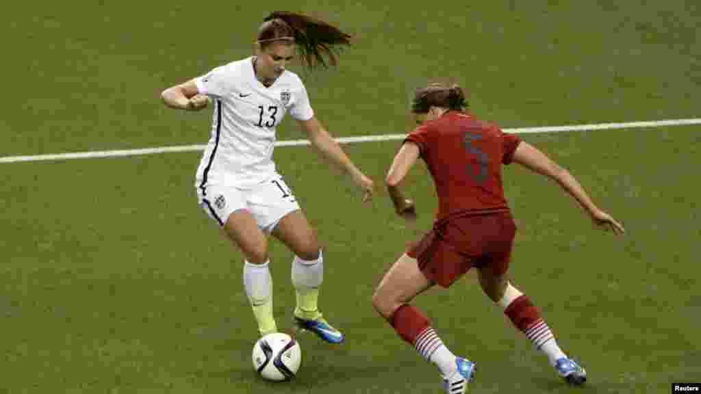 &#39;Yar wasan Amurka Alex Morgan (13) ta yanke Annike Krahn na Jamus. 30 ga watan Yuni, 2015