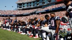 FILE - Several New England Patriots players kneel during the national anthem before an NFL football game against the Houston Texans in Foxborough, Mass., Sept. 24, 2017.