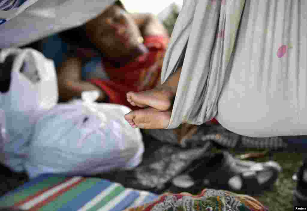 Para warga desa yang melarikan diri dari pertempuran antara pasukan pemerintah dan pasukan pemberontak Muslim, beristirahat di dalam tenda-tenda mereka di sepanjang jalan Zamboanga, Filipina (18/9).&nbsp;(AP/Bullit Marquez)