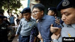 路透社記者瓦龍2018年4月11日被警方押離法庭。(路透社照片)