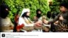 FILE - This screen grab from an Islamic State group affiliated Twitter account, taken Sunday, Sept. 20, 2014, purports to show senior military commander Abu Wahib handing a flower to a child while visiting southern Iraq, as part of the group's broad social media campaign.