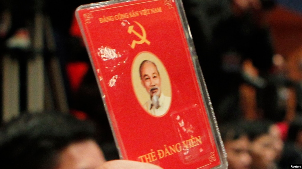 A delegate of Vietnam's Communist Party raises his membership card to vote on new policies at the closing ceremony of the 11th National Congress of the Party in Hanoi January 19, 2011