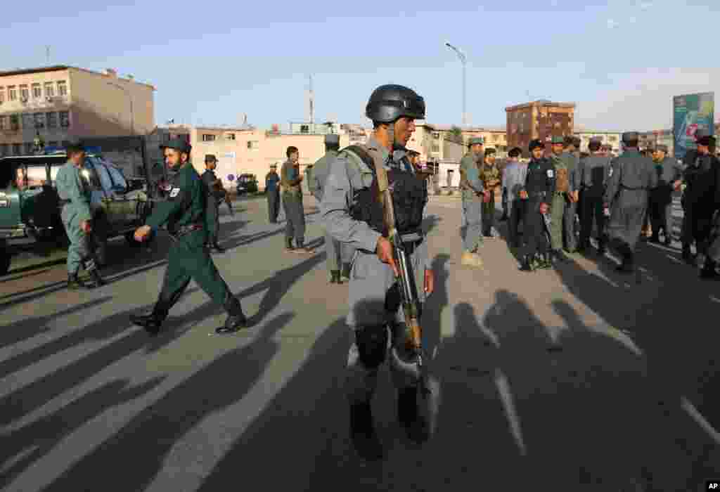Afghan security forces inspect the site of a suicide car bombing attack in Kabul, May 19, 2015.