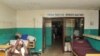 Des personnes attendent devant l'unité de soins intensifs de l'hôpital Phebe, dans la ville de Bong, dans le centre du Libéria, le 27 mai 2019.