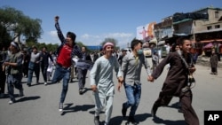Protesters run during a massive anti-government protest in Kabul, Afghanistan, May 16, 2016. 