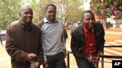Zimbabwean journalists Brian Chitemba, left, Mabasa Sasa, center, and Tinashe Farawo walk in handcuffs, outside the magistrates courts in Harare, Zimbabwe, Nov. 4.2015.