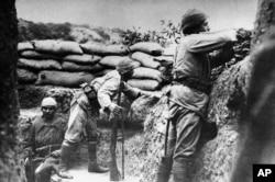 FILE - In this 1915 file photo, a Turkish soldier takes aim at British troops, while another watches carefully, from a trench in Gallipoli, Turkey.