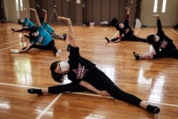 Anggota tim pemandu sorak senior Jepang "Japan Pom Pom" melakukan pemanasan sebelum latihan di Tokyo, 26 Juli 2021, saat kota tersebut menjadi tuan rumah Olimpiade Tokyo 2020. (AFP)