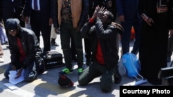 Somali migrants kneel and pray after arriving back in the Somali capital, Mogadishu, Feb. 17, 2018. (Somali Ministry of Information)