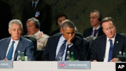 Presiden AS Obama (tengah), PM Inggris David Cameron (kanan), dan Menteri Pertahanan AS Chuck Hagel (kiri) mendengarkan pidato Sekjen NATO Anders Fogh Rasmussen dalam KTT NATO di Celtic Manor, Newport, Wales (5/9/2014). 