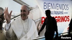 A passenger walks past a poster of Pope Francis at the Tocumen International Airport ahead of Pope Francis' visit for World Youth Day, in Panama City, Panama, Jan. 21, 2019.