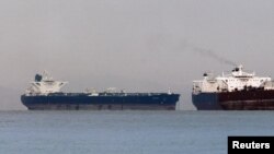 Sebuah kapal tanker Iran 'Delvar' (kiri) tengah berlabuh di Singapura (Foto: dok). Uni Eropa akan memberlakukan embargo atas ekspor minyak Iran pada hari Minggu (1/7).