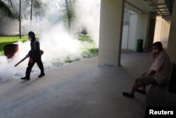 A resident shields his nose as pest control officer carry out fogging in the Aljunied Crescent cluster in Singapore, Sept. 3, 2016 in this photo taken by Antara Foto.