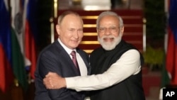 Russian President Vladimir Putin, left and Indian Prime Minister Narendra Modi greet each other before their meeting in New Delhi, India, Dec.6, 2021. 