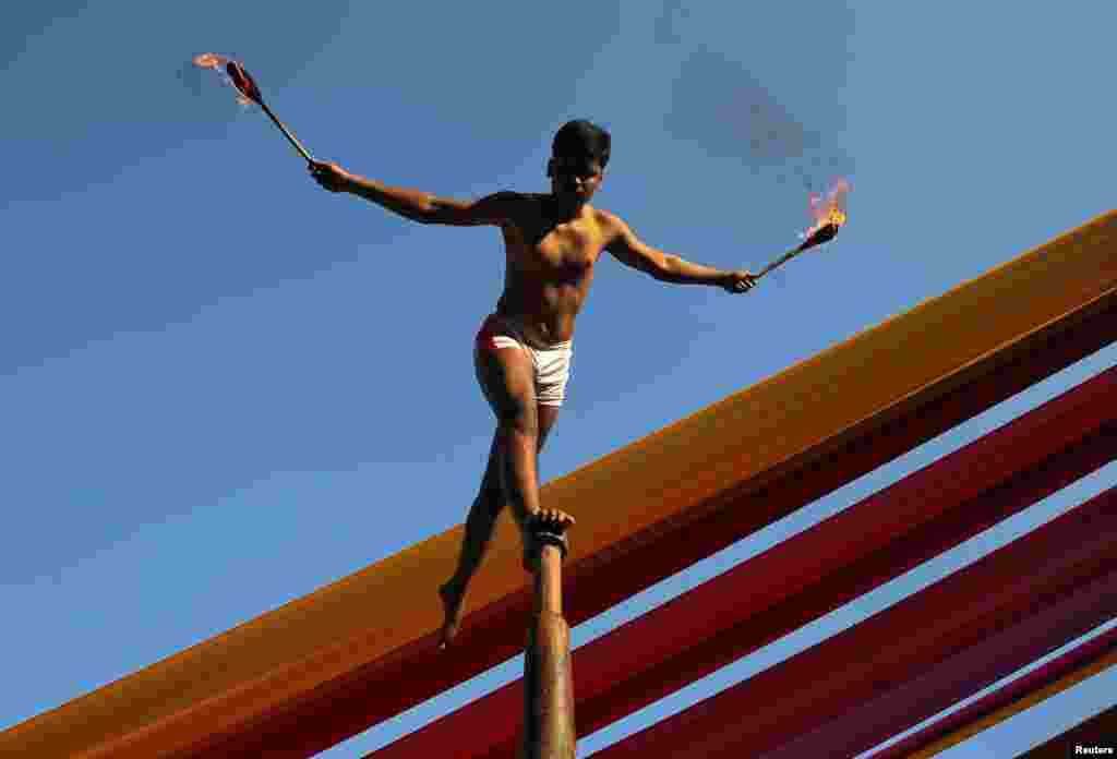 A man performs &quot;Malkhamb&quot; (traditional Indian gymnastics) during a college festival in Mumbai, India.