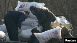 지난 2008년 12월 북한 신의주 주민들이 미국에서 지원한 식량을 트럭에서 내리고 있다. 식량 자루에 'USAID(미국제개발처)' '미국에서 보내온 선물' 이란 문구가 씌여있다.