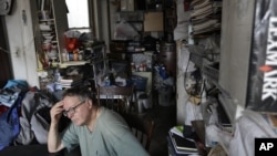 FILE - A man pictured in his cluttered home.