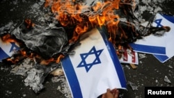 A protester burns an Israeli flag during a rally to condemn Washington's decision to recognize Jerusalem as Israel's capital, outside the U.S. embassy in Jakarta, Indonesia, Dec. 15, 2017.