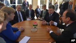 Clockwise, from left, German Chancellor Angela Merkel, Russian President Vladimir Putin, Ukrainian President Petro Poroshenko and French President Francois Hollande hold an informal meeting in Paris, France, Oct. 2, 2015.