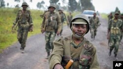 Congolese army soldiers march into Kibumba town after recapturing it from M23 rebels over the weekend, around 25km from the provincial capital Goma, in eastern Congo Monday, Oct. 28, 2013.