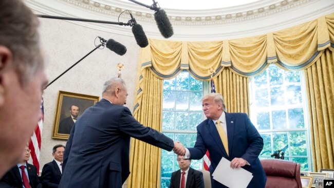 特朗普总统在2019年10月11日星期五在华盛顿白宫椭圆形办公室与中国副总理刘鹤握手。