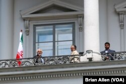 Iranian Foreign Minister Mohammad Javad Zarif, left, stands on the balcony of Palais Coburg, the venue for nuclear talks, in Vienna, Austria, July 2, 2015.