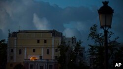 FILE - The streets of Old San Juan are dark after sunset one month after Hurricane Maria in San Juan, Puerto Rico, Oct. 20, 2017. 