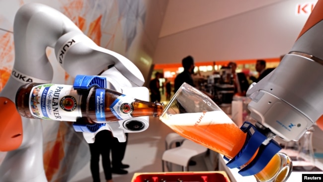 已被中国美的公司收购的德国机器人巨头“库卡”公司在汉诺威举行的工业展销会上展示机器人手臂倒一杯德国啤酒。（2017年4月24日） 