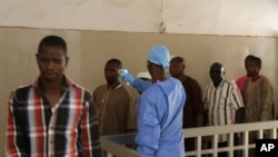Ảnh tư liệu - Một nhân viên y tế (giữa) đo nhiệt độ của người dân để kiểm tra xem liệu họ có bị nhiễm virus Ebola hay không tại bệnh viện công Ignace Deen ở Conakry, Guinea, ngày 18 tháng 3 năm 2016.