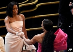 Regina King, left, and Angela Bassett shake hands in the audience prior to the start of the Oscars on Sunday, Feb. 24, 2019, at the Dolby Theatre in Los Angeles. (Photo by Chris Pizzello/Invision/AP)