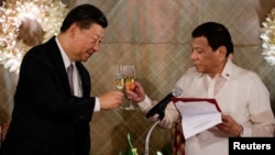 FILE - China's President Xi Jinping and Philippine President Rodrigo Duterte toast during a State Banquet at the Malacanang presidential palace in Manila, Philippines, Nov. 20, 2018.