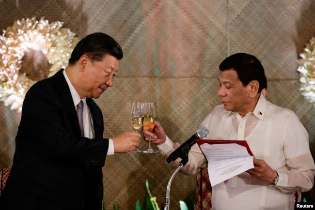 FILE - China's President Xi Jinping and Philippine President Rodrigo Duterte toast during a State Banquet at the Malacanang presidential palace in Manila, Philippines, Nov. 20, 2018.