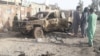 Residents look at an Army vehicle which was damaged during battle between Afghan security forces and Taliban in Farah province, Afghanistan, May 16, 2018. 