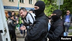 Police officers detain an anti-government protester during a rally calling for a boycott of June presidential elections in Almaty, Kazakhstan, May 1, 2019.