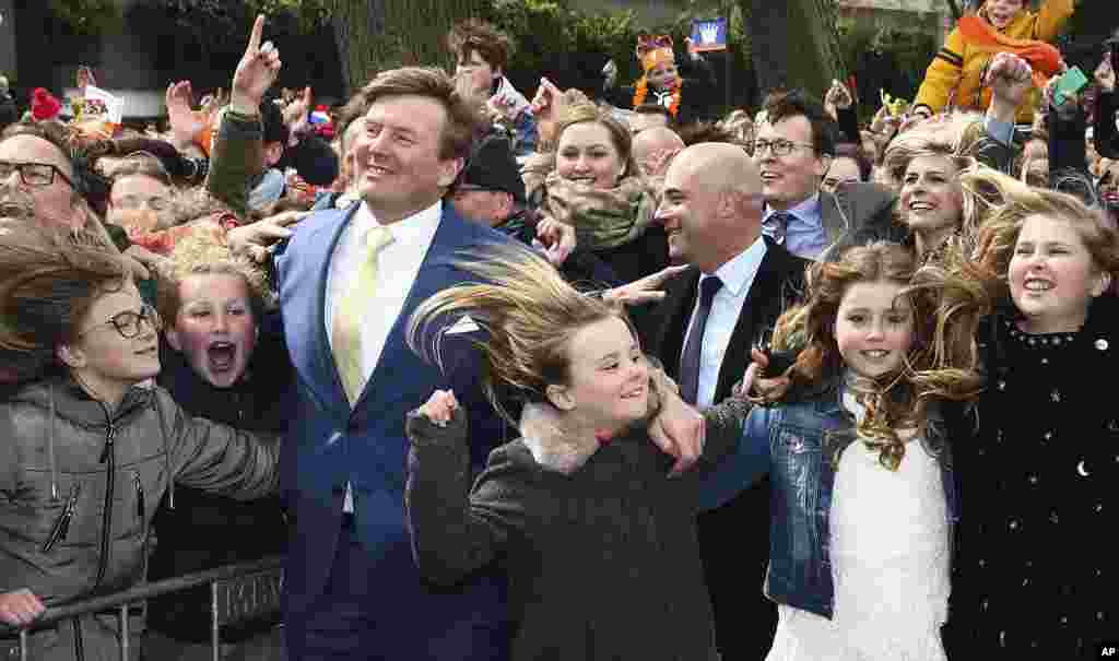 Dutch King Willem-Alexander, left, and his daughters Princess Ariane, third right, Princess Alexia, second right, and Crown Princess Catharina-Amalia, right, dance during King&#39;s Day celebrations in Zwolle, the Netherlands.