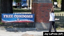 A volunteer for AIDS Healthcare Foundation's "Condom Nation" distributes free condoms to passers by outside Columbus Public Health in Columbus, Ohio. Condom Nation is a serious, yet creative effort by AIDS Healthcare Foundation to help promote increased c