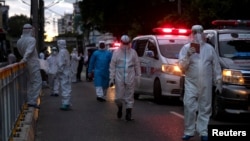 PPE ဝတ်စုံပြည့်ဝတ်ထားတဲ့ ကျန်းမာရေးဝန်ထမ်းများကို ရန်ကုန်မြို့ရှိ လမ်းတခုမှာ တွေ့ရ။ (စက်တင်ဘာ ၂၇၊ ၂၀၂၀)