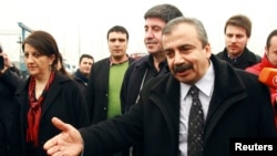 FILE - Pro-Kurdish politicians Sirri Sureyya Onder (R), Pelvin Buldan (L) and Altan Tan (C), are surrounded by media members before leaving for Imrali island in Istanbul, Feb. 23, 2013. 